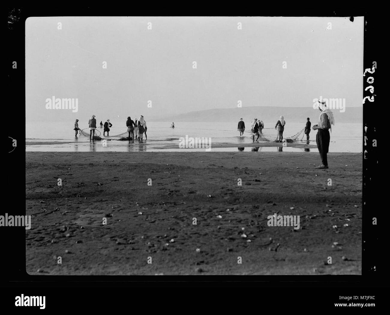 L'image illustre le concept d'un filet jeté dans la mer, symbolisant le rassemblement de personnes ou d'idées. Il évoque des thèmes d’inclusion et de connexion, encadrés par une lentille métaphorique. Banque D'Images