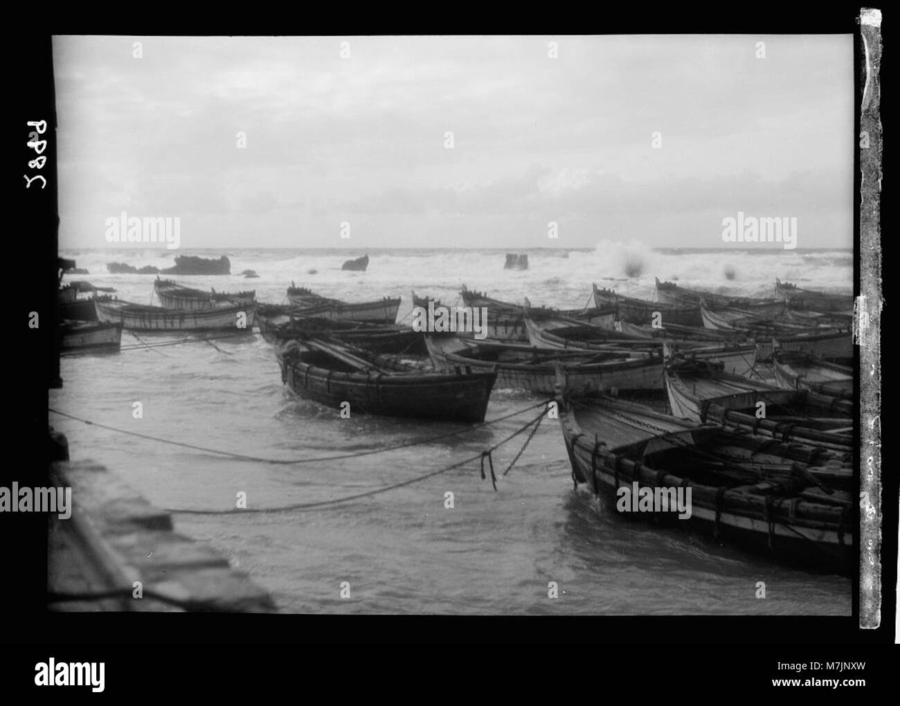Une scène dramatique représentant la mer orageuse au large de la côte de Jaffa, avec des péniches naviguant entre les rochers sur leur chemin vers Jérusalem. Banque D'Images