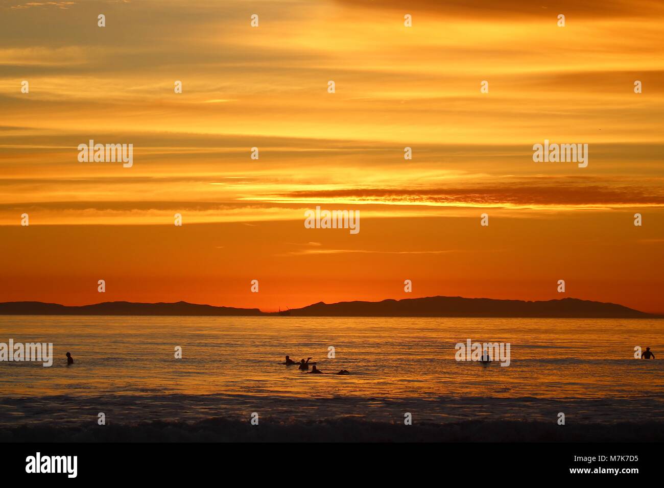 Coucher du soleil orange avec des silhouettes d'internautes Banque D'Images