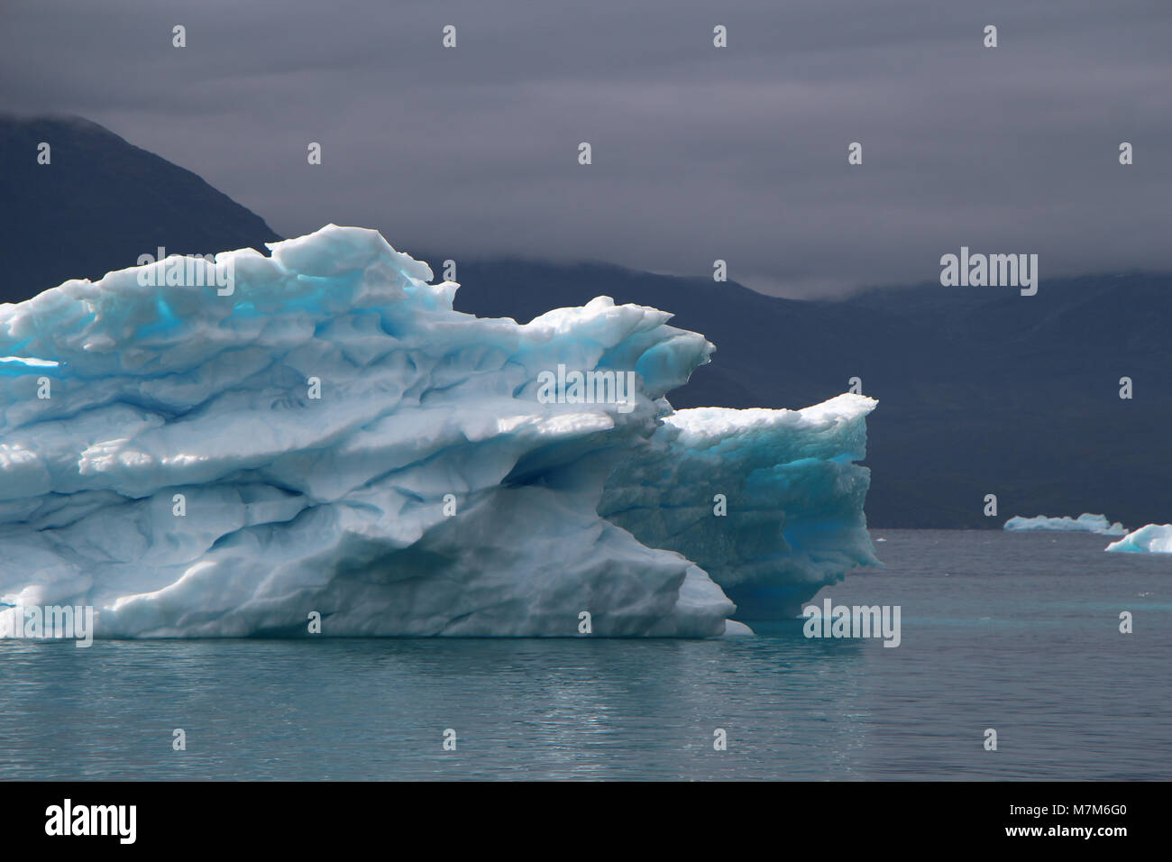 Iceberg bleu avec des taches à l'intérieur beige et aussi avec l'humeur spectaculaires du ciel dans l'océan Atlantique Banque D'Images