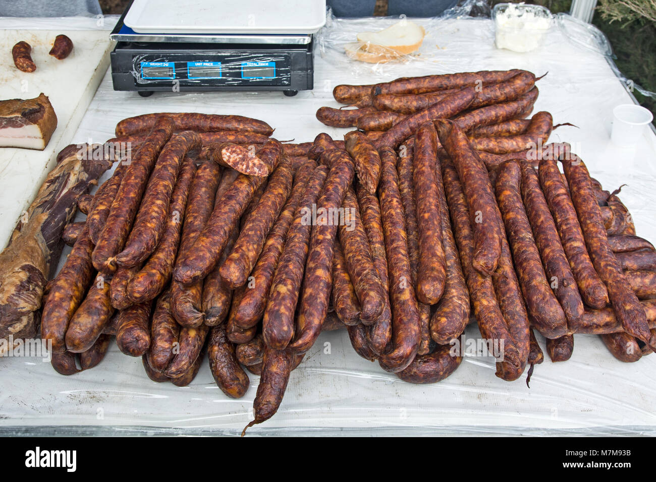 Des saucisses de porc fumé et séché debout sur la table pour la vente. Banque D'Images Des saucisses de porc fumé et séché debout sur la table pour la vente. Banque D'Images
