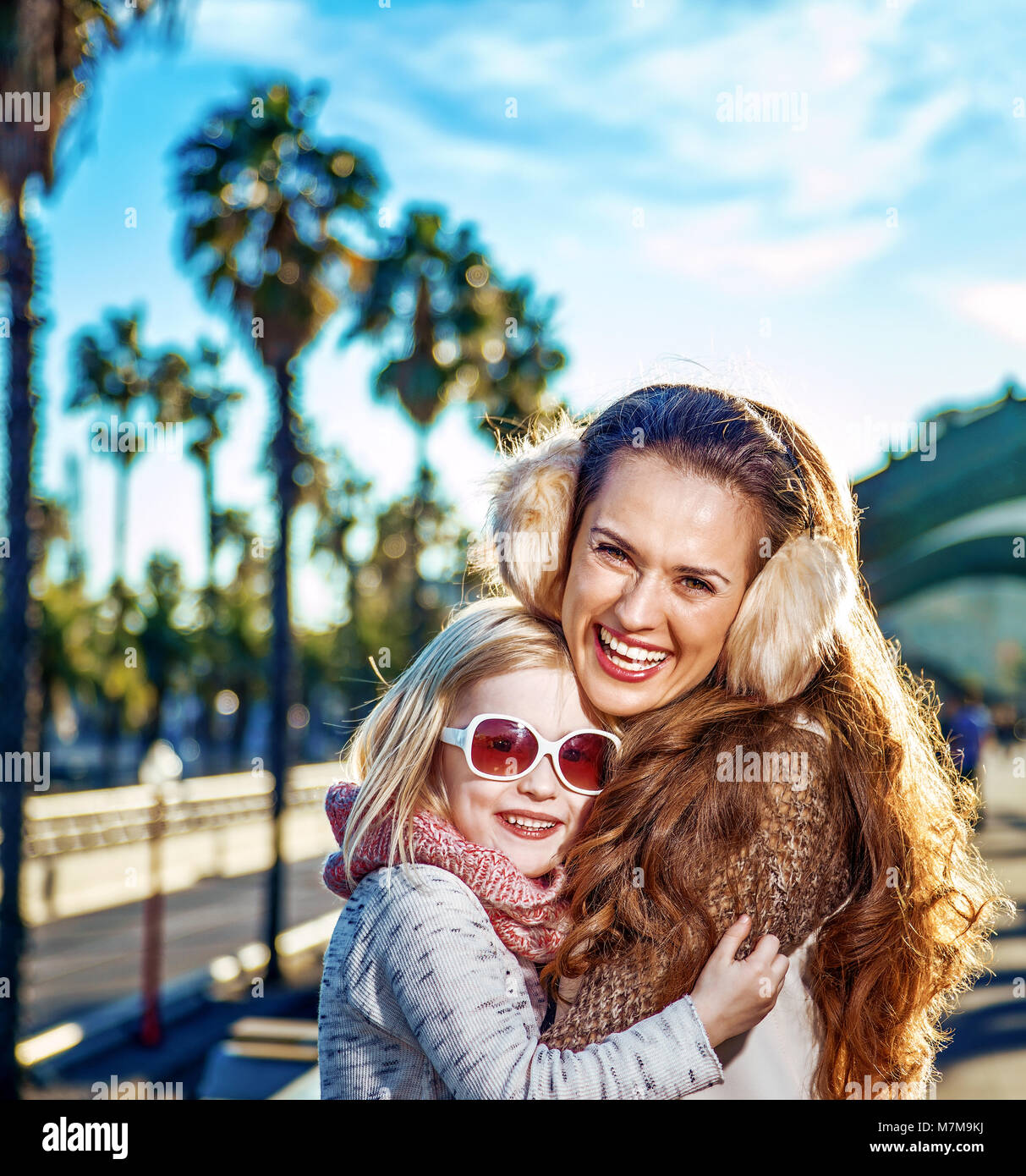 À Barcelone pour un hiver parfait. smiling modern mother and daughter touristes sur le quai à Barcelone, Espagne hugging Banque D'Images