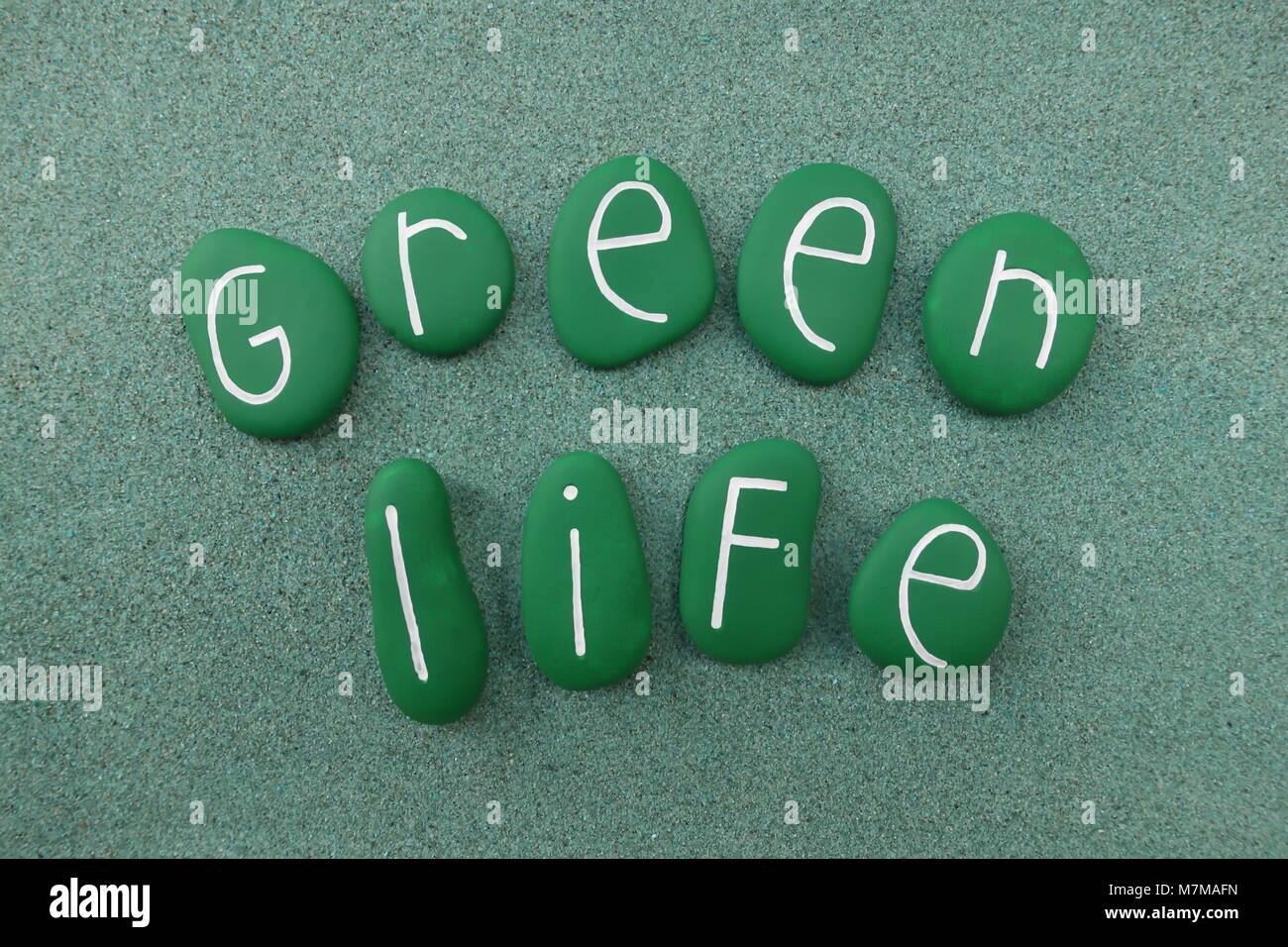 Green life texte avec plus de pierres peintes en vert de sable vert Banque D'Images
