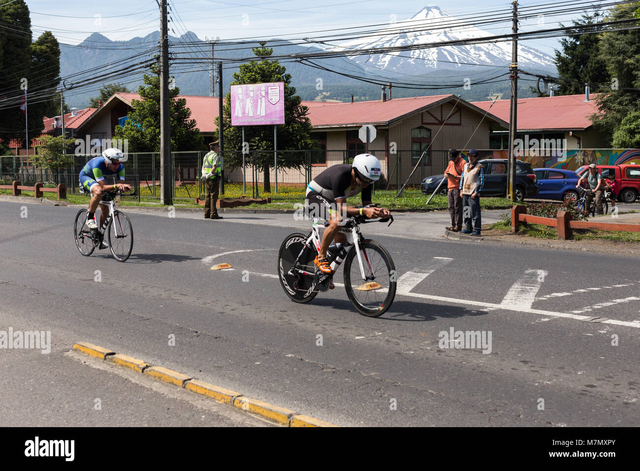 Les athlètes sur leurs vélos en passant par une ville au cours de l'Ironman 70.3 Pucon 2018 Banque D'Images