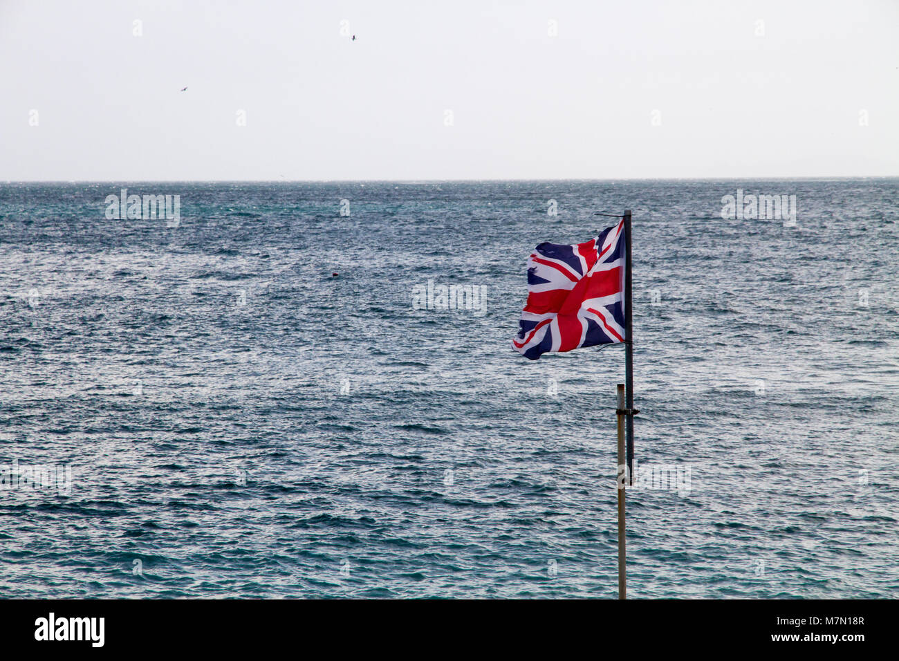 Drapeau britannique sur fond de mer à Gibraltar, territoire britannique dans l'Europe. Banque D'Images