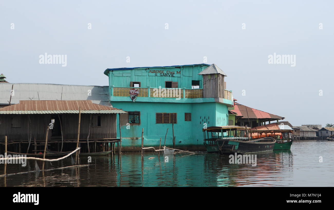 Bâtiment coloré et un bateau dans le village sur pilotis Ganvie, sur le Lac Nokoué au Bénin, Afrique de l'Ouest Banque D'Images