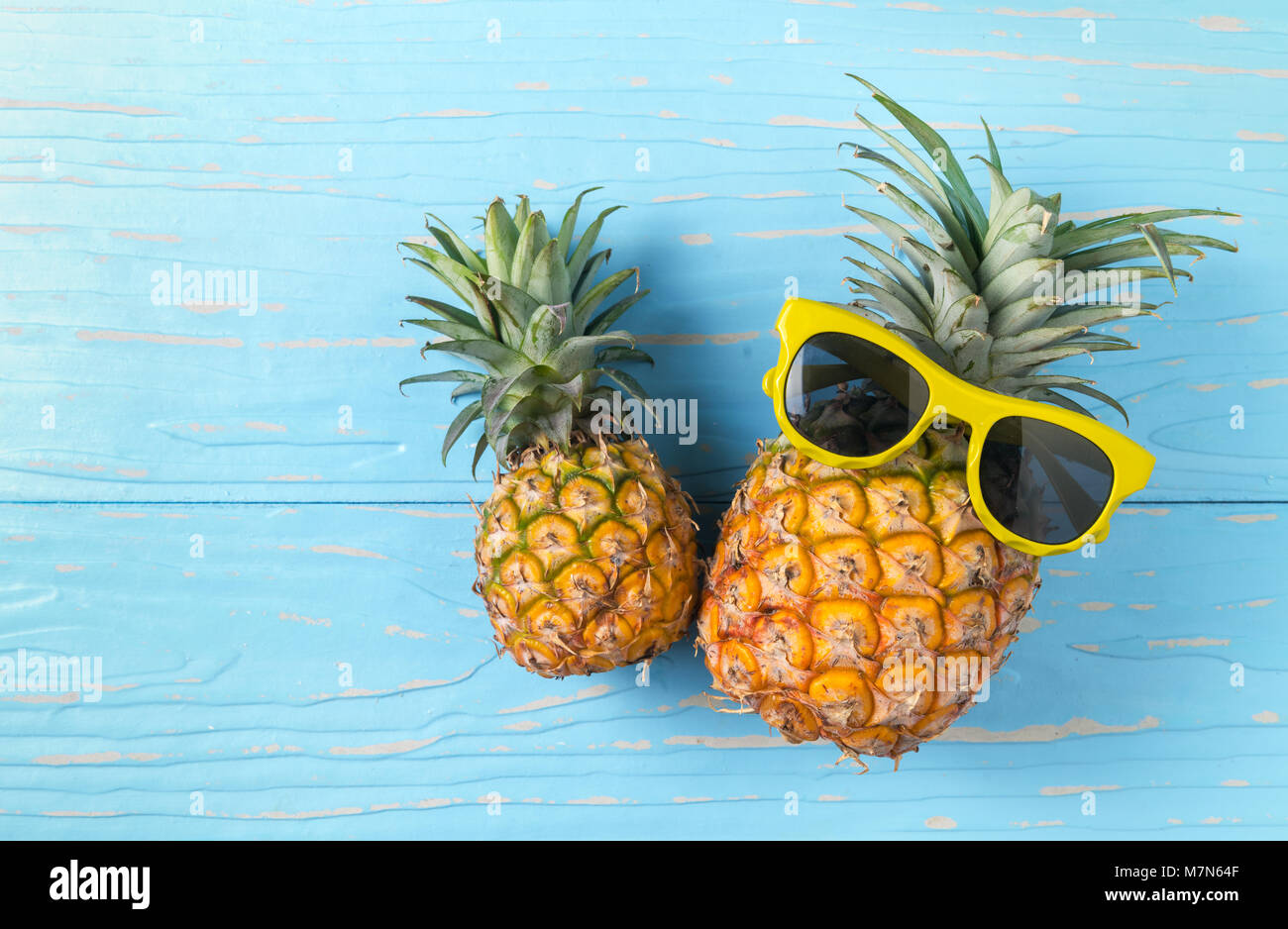 L'ananas avec des lunettes de soleil sur fond de bois bleu, concept fruits  d'été Photo Stock - Alamy