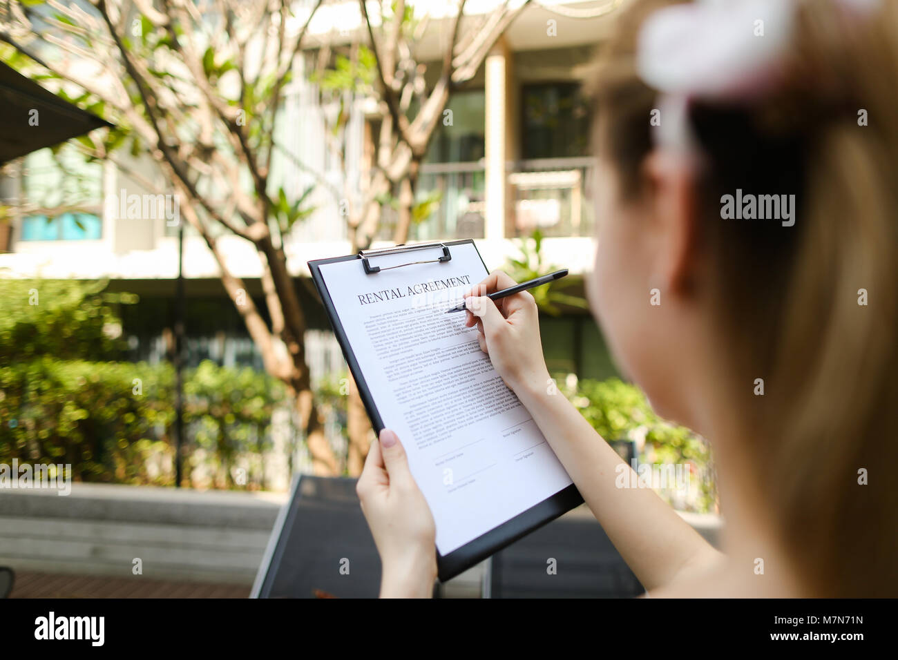 Signature de contrat de location d'une journée ensoleillée, femme Banque D'Images