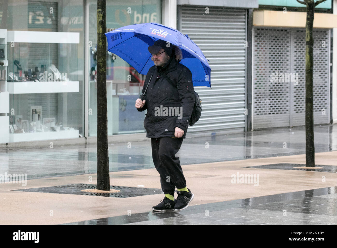 Southport, Merseyside. 12 mars 2018. Météo britannique. Tôt le matin, de fortes averses pleuvent sur les consommateurs comme ils l'abri sous leurs parasols à Southport dans le Merseyside. Une averse de pluie des éclosions se poursuivra cet après-midi, dont certaines seront longues. Quelques éclats lourds avec un risque de Thunder sont possible plus tard dans l'après-midi. Credit : Cernan Elias/Alamy Live News Banque D'Images