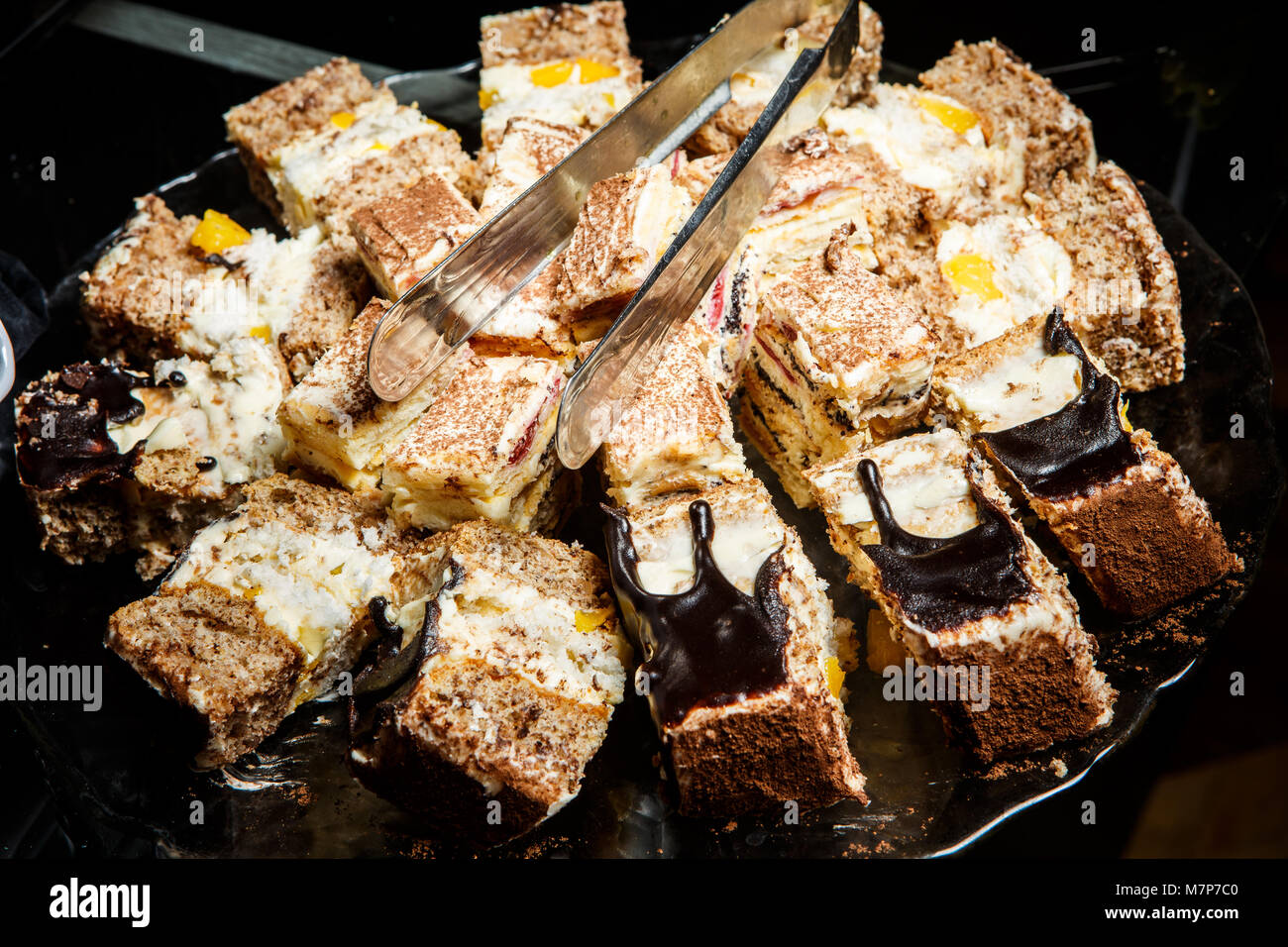Assortiment de gâteau fait maison avec des graines de pavot versé avec du chocolat et de la tarte aux pommes servi sur la plaque Banque D'Images