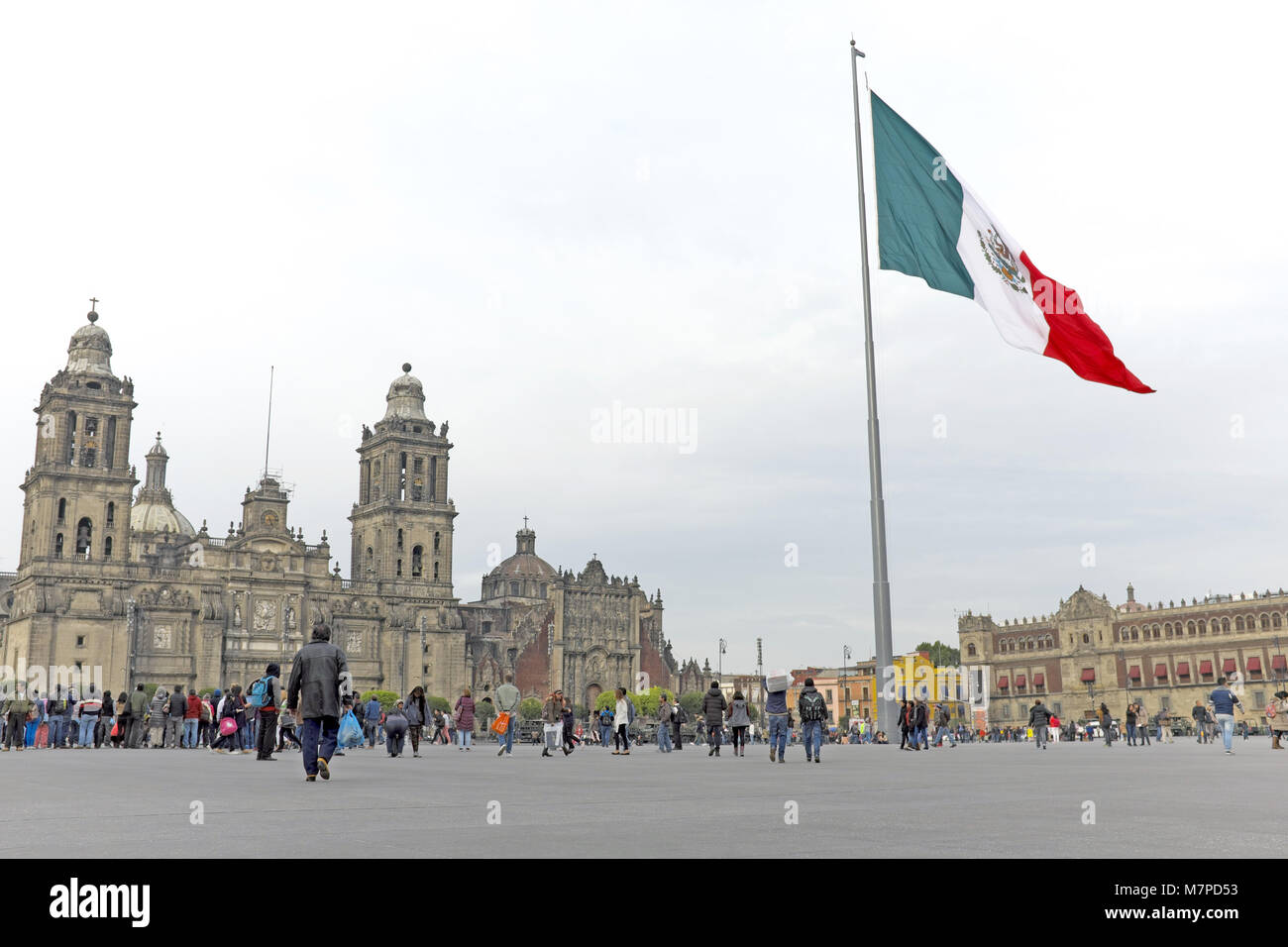 Le drapeau national du Mexique vagues au-dessus de la ville de Mexico zocalo, la place publique entourée par le Palais National et la cathédrale de Mexico. Banque D'Images