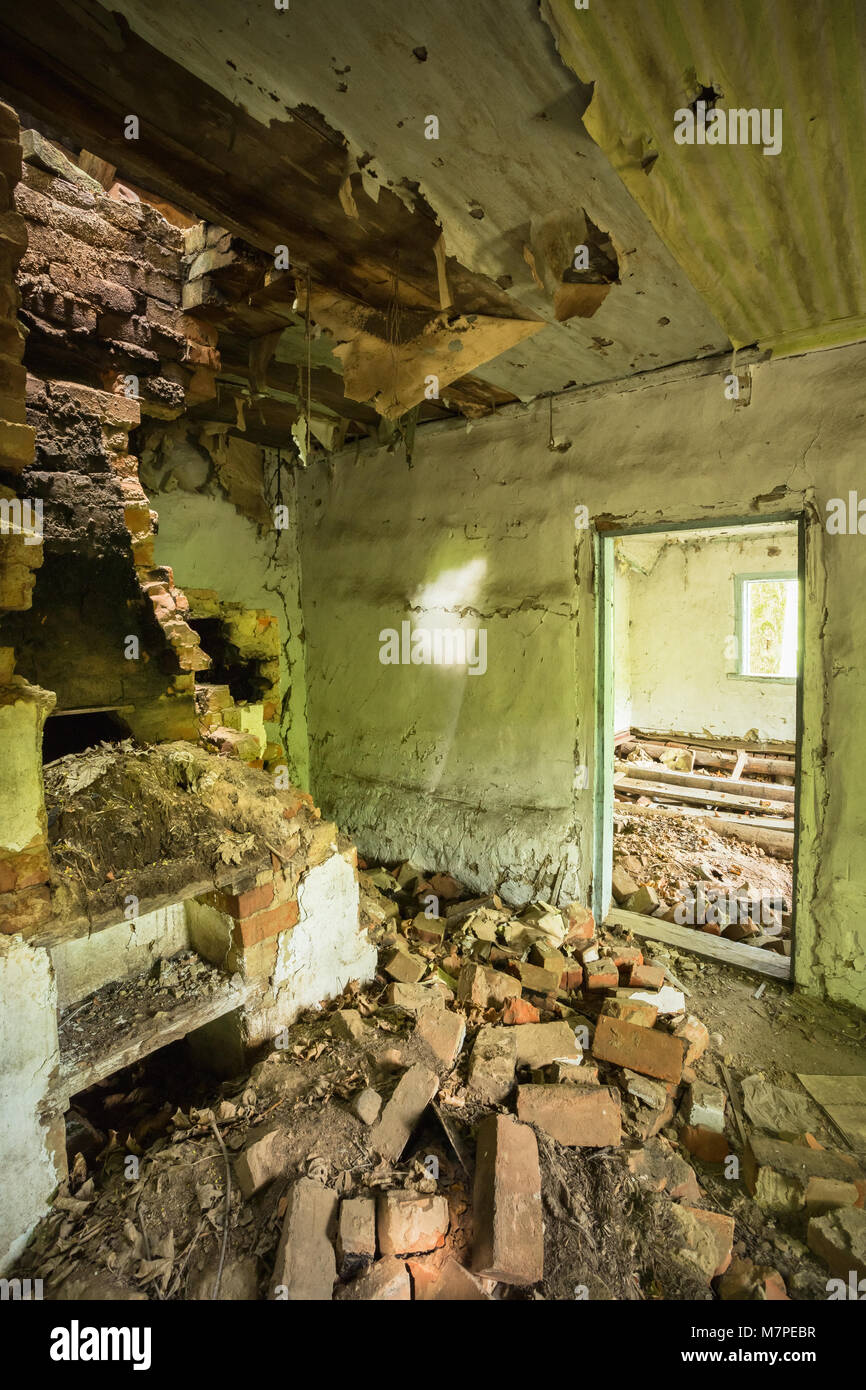 Le four en brique four en ruine abandonnée, maison détruite dans la zone de contamination nucléaire après la catastrophe de Tchernobyl. Banque D'Images