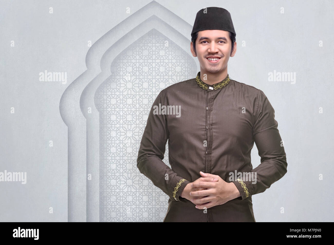 Smiling asian musulman avec le chapeau et le costume traditionnel dans la mosquée Banque D'Images