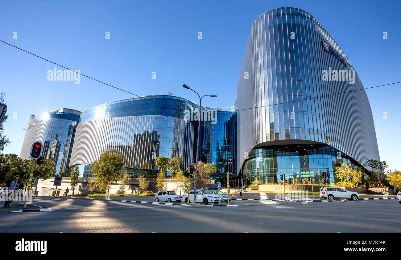 Johannesburg, Afrique du Sud - 8 mars, 2018 : bâtiment moderne à la façade de verre avec en premier plan la route. La réflexion de la lumière sur la route. Banque D'Images