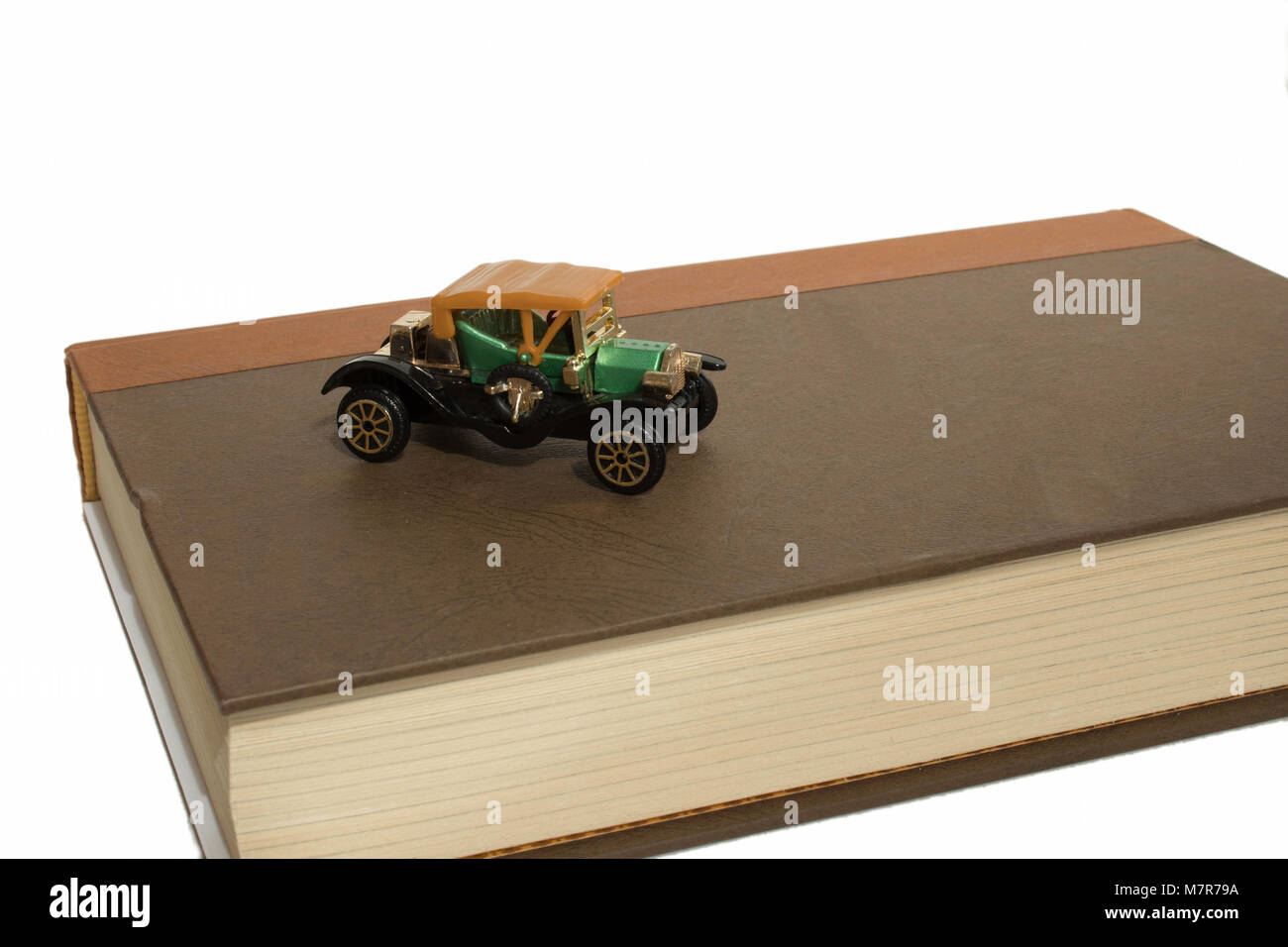 Old Fashioned toy voiture sur livre brun avec copie espace vers la droite. Banque D'Images