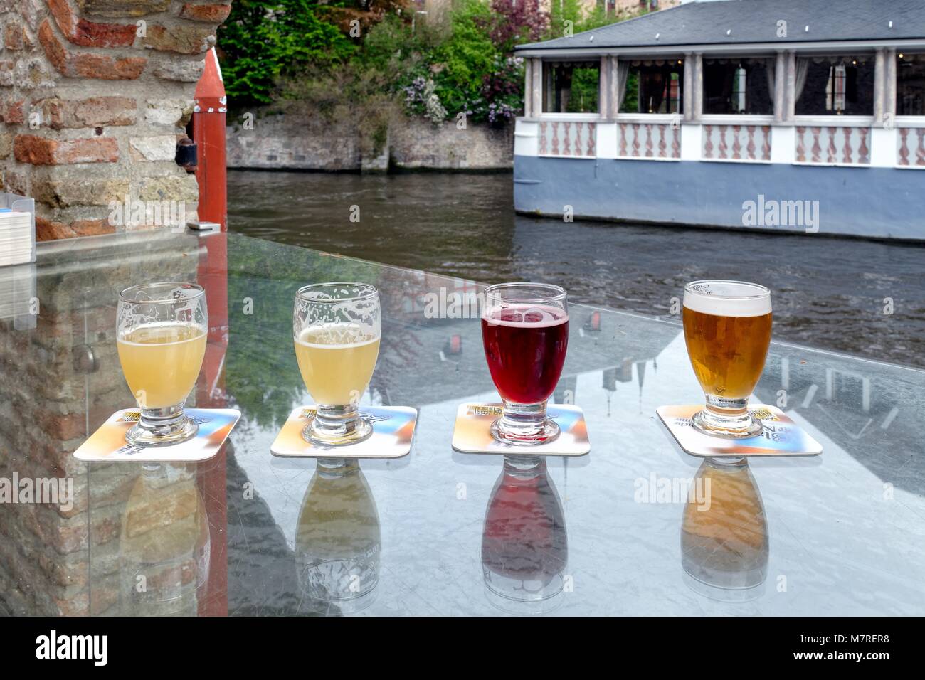 Portrait de quatre verres de bière en Belgique on outdoor table bar par canal de Bruges Belgique Banque D'Images