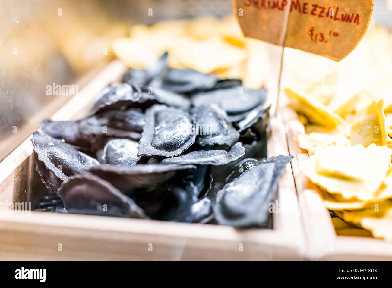 Noir de l'encre de seiche crevettes raviolis pâtes fraîches mezzaluna nouilles brutes charbon non cuites en italien marché gourmand Banque D'Images