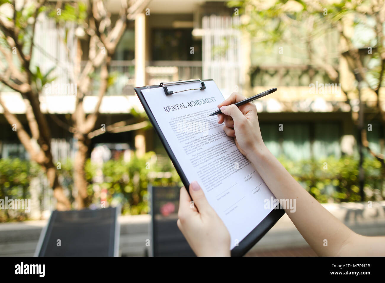 Close up of woman mains signature contrat de location condo sunny day Banque D'Images