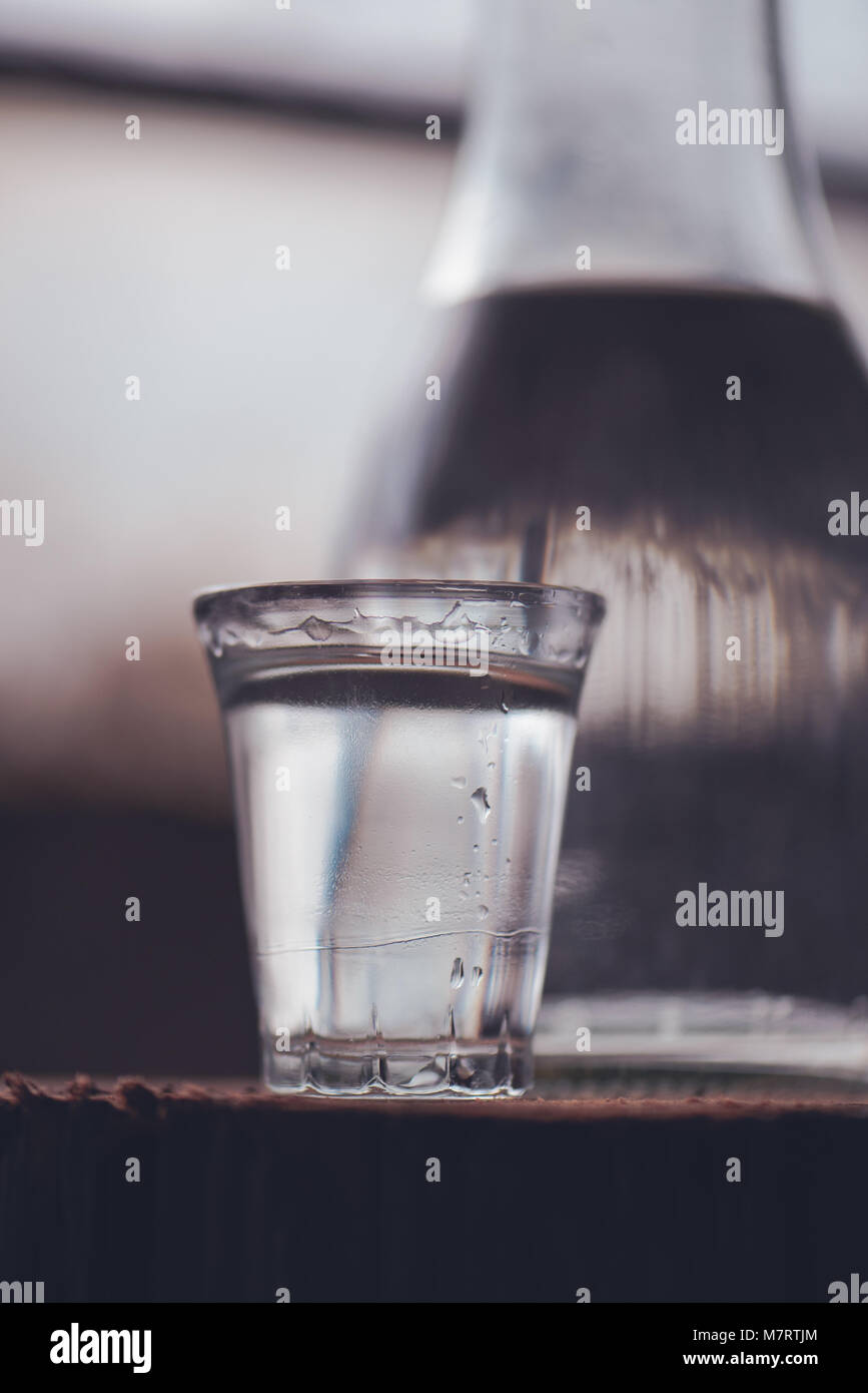 Boire de l'alcool fort en bouteille avec coup du verre dans l'atmosphère rustique traditionnel aux couleurs rétro Banque D'Images