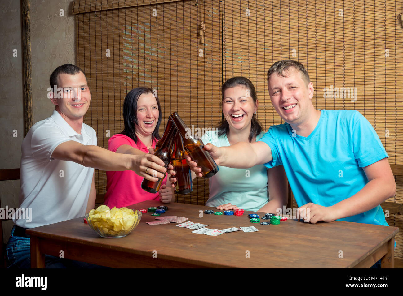 Cheerful friends boire de la bière à l'intérieur jeu de carte Banque D'Images