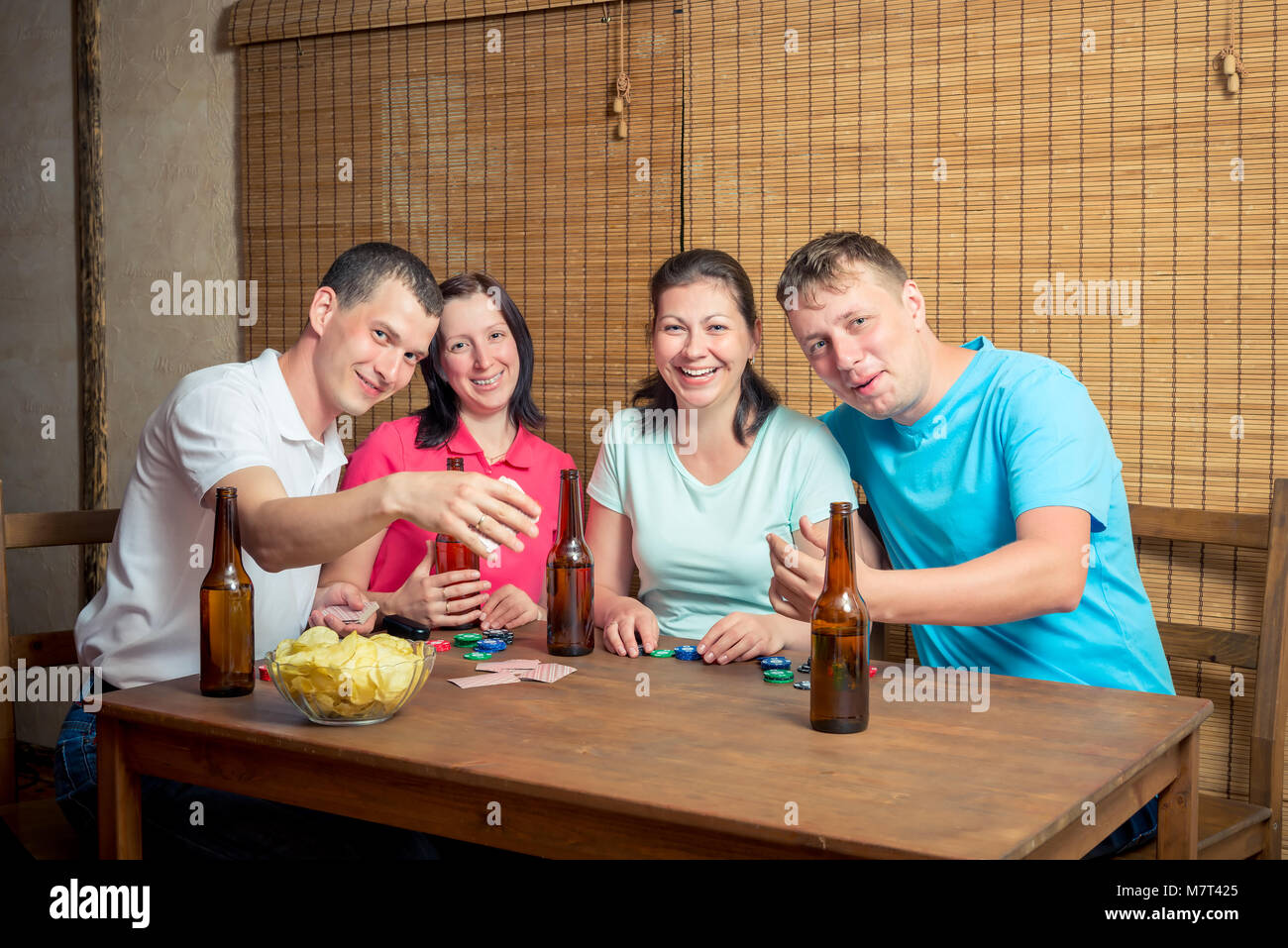 Smiling friends en jouant au poker à la table Banque D'Images