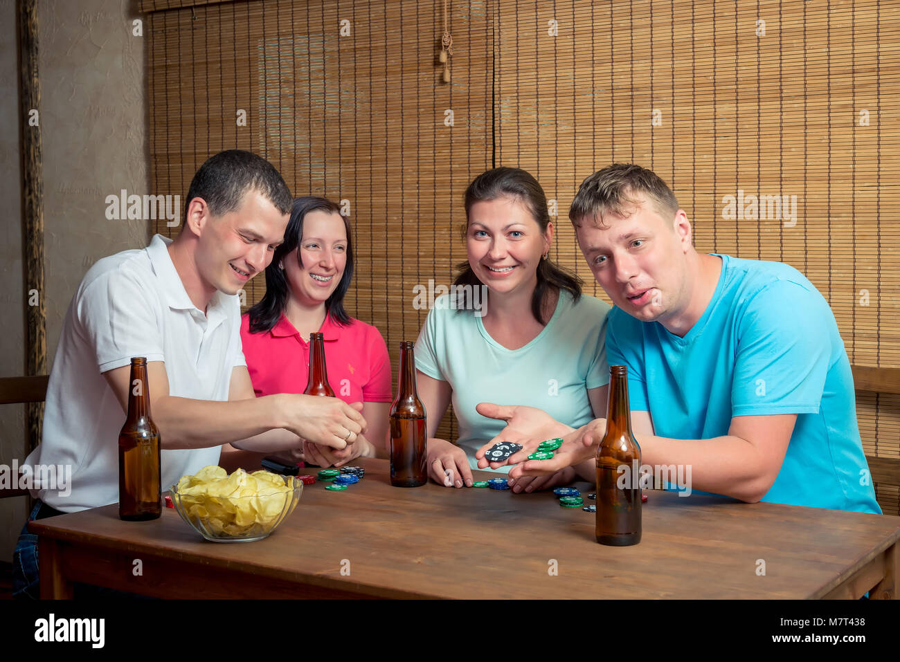 Les amis en jouant au poker, les gens à la table avec de la bière et des cartes Banque D'Images