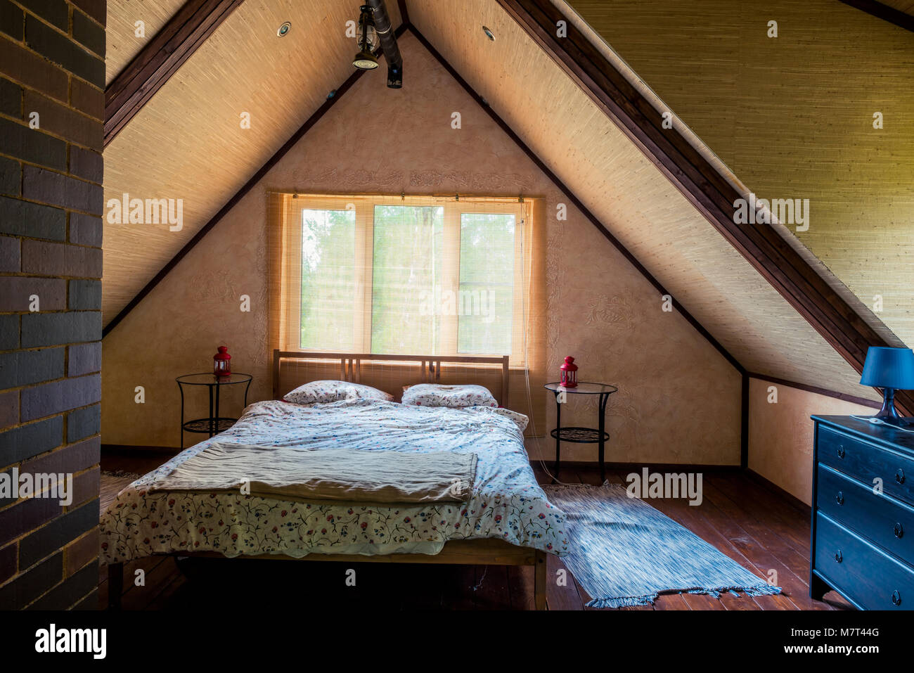 Intérieur d'une chambre avec un lit à l'étage supérieur d'une maison en bois, sous un toit Banque D'Images
