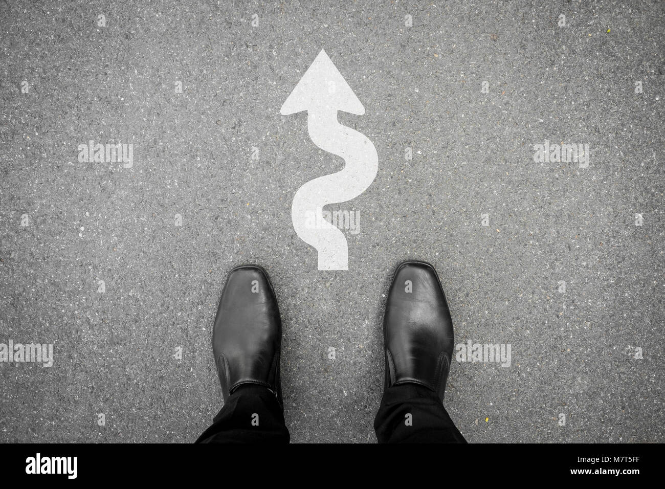Businessman standing on the street et dur et difficile chemin à suivre direction marbre signe en face de lui Banque D'Images