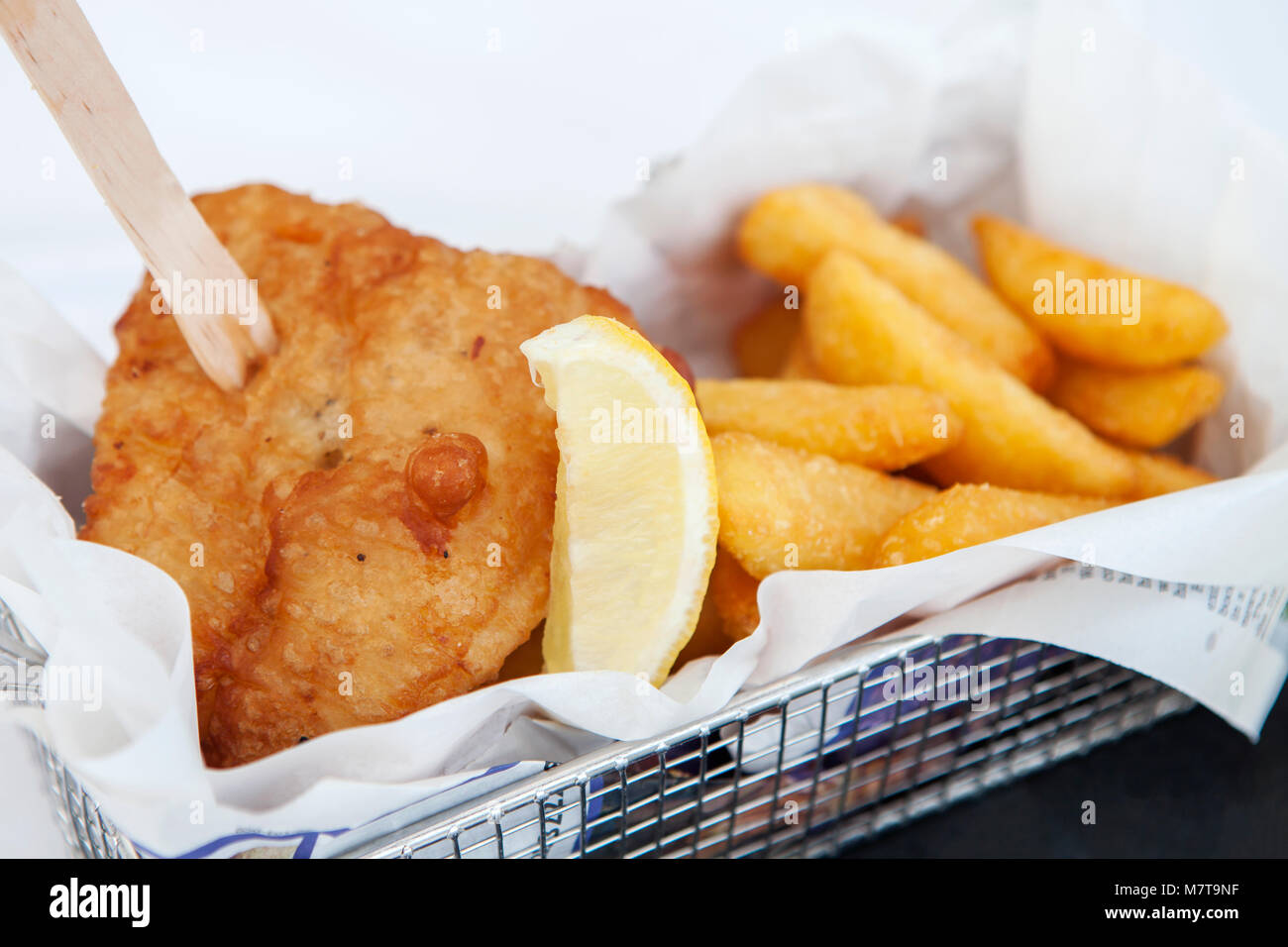 Fish and chips, à l'aide d'une fourchette dans un panier métallique. Banque D'Images