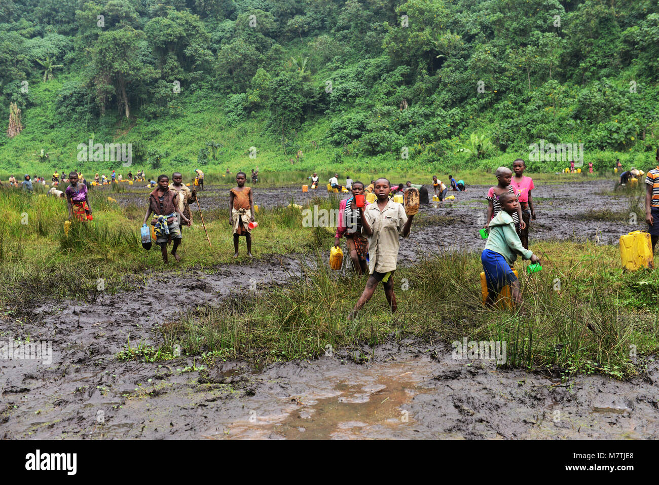 Les villageois congolais remplir leur approvisionnement en eau de ce bassin boueux. La seule bonne source d'eau qu'ils ont. Banque D'Images