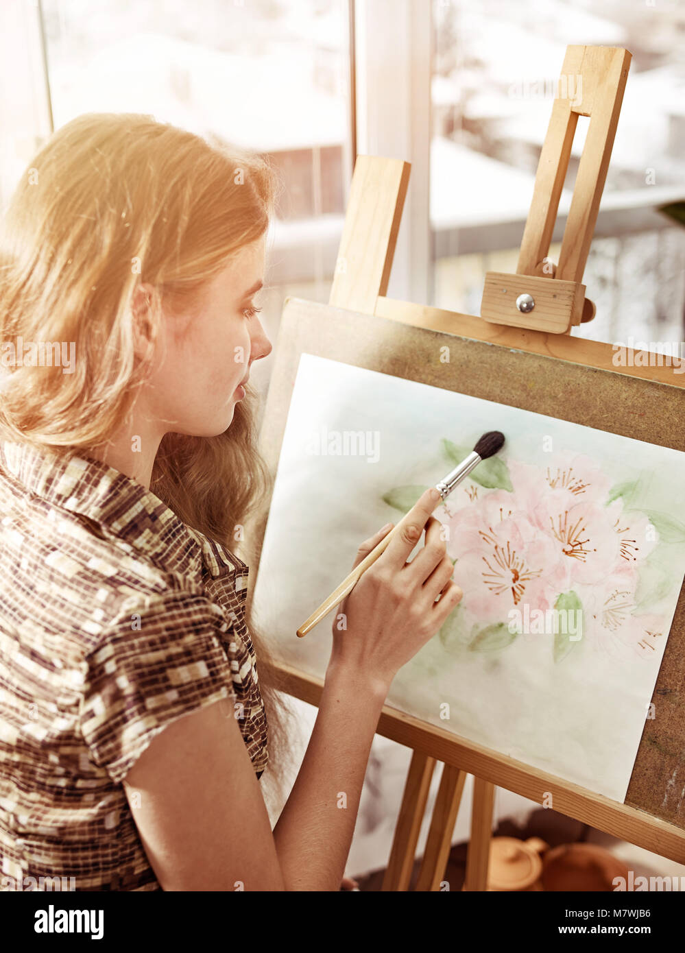 Artiste peinture sur chevalet dans Studio. Les peintures de fille avec un pinceau. Banque D'Images