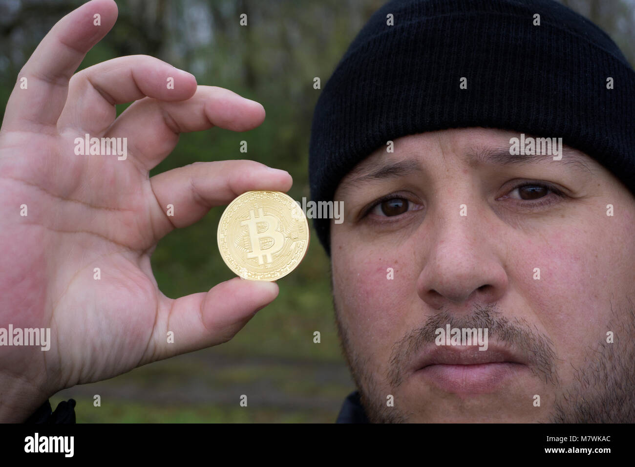 Bitcoin fou amoureux avec une pièce d'or dans votre main , drôle miner avec BTC près du visage Banque D'Images