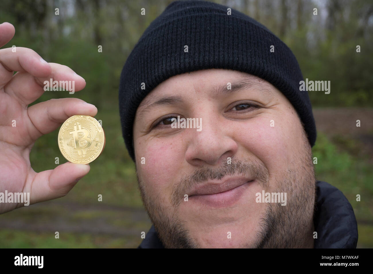 Bitcoin fou amoureux avec une pièce d'or dans votre main , drôle miner avec BTC près du visage Banque D'Images