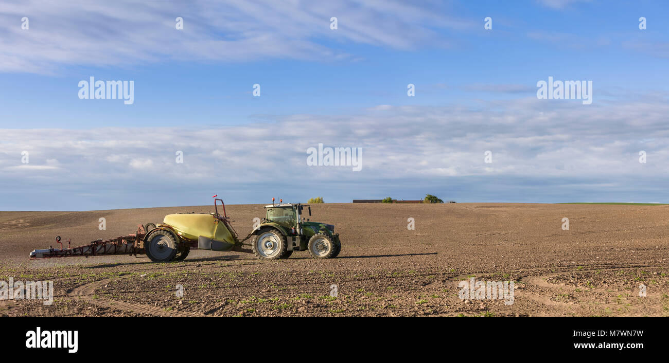 La pulvérisation d'engrais du tracteur sur le terrain agricole Banque D'Images