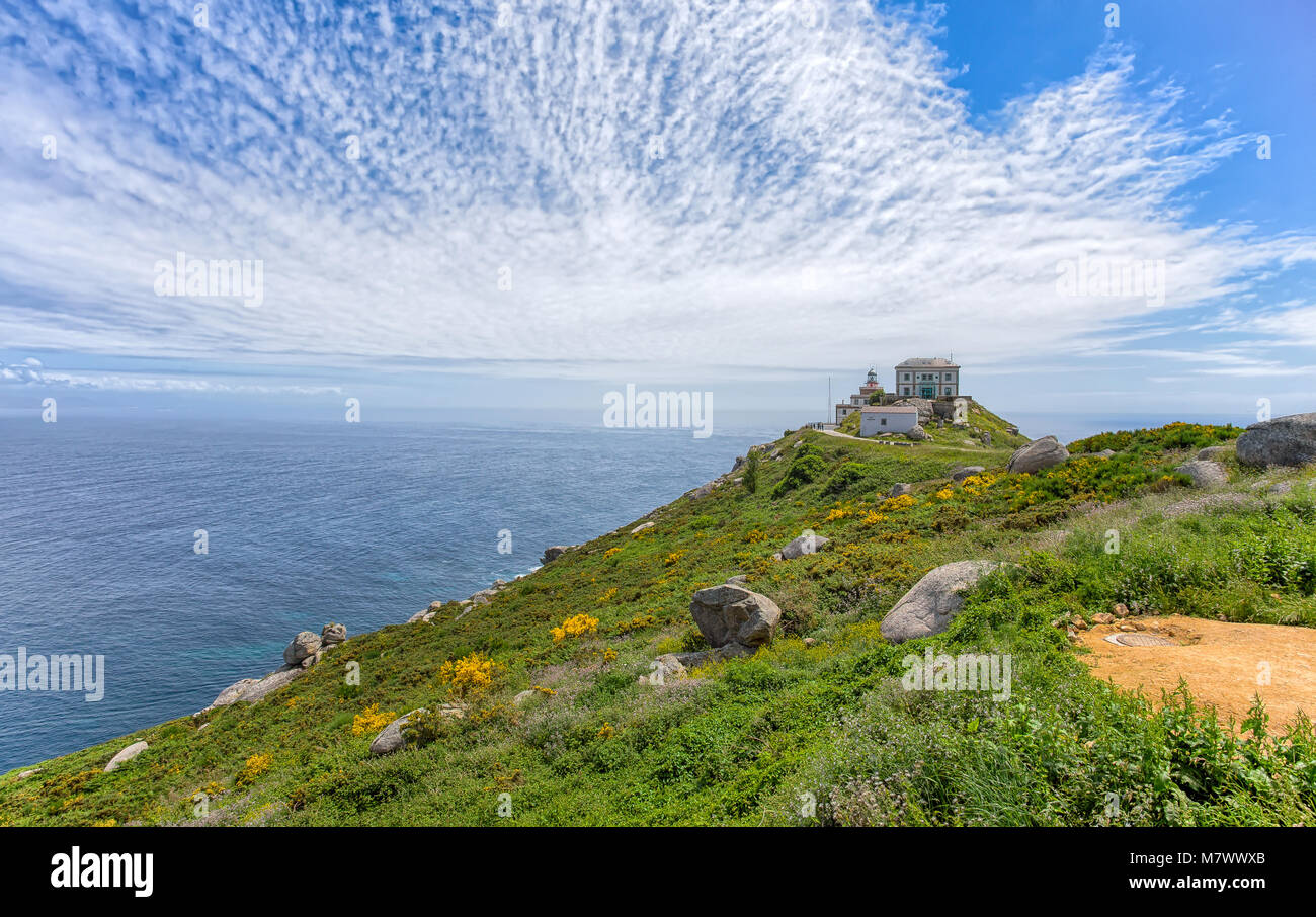Vue sur le cap Finisterre, Galice, Espagne avec le phare sous un ciel nuageux ciel bleu Banque D'Images