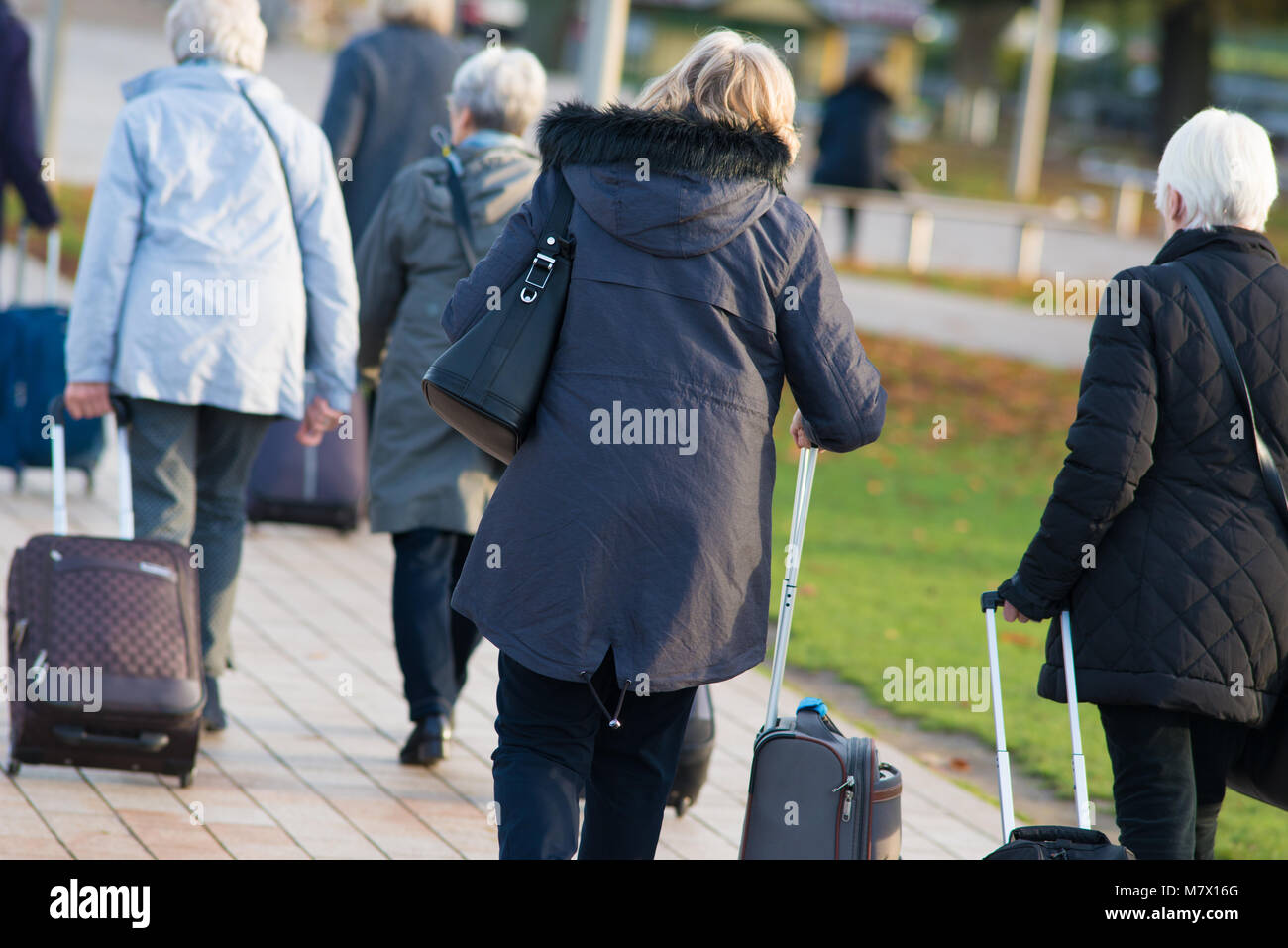 Les femmes d'âge moyen dans la région de rush avec des sacs de vol après l'avion disparu d'être perdu et marche à travers park Banque D'Images