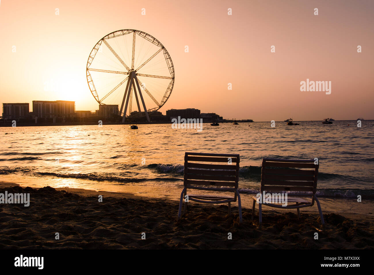 Deux chaises longues avec vue sur la grande roue Ain Dubai à JBR plage au coucher du soleil Banque D'Images