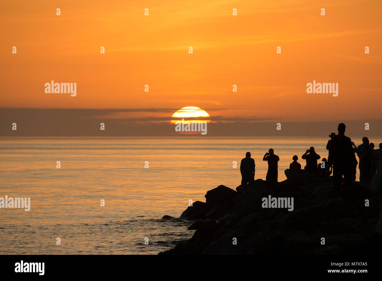 Les gens qui suivent le coucher du soleil sur le golfe du Mexique sur la jetée sud à Venise en Floride Banque D'Images