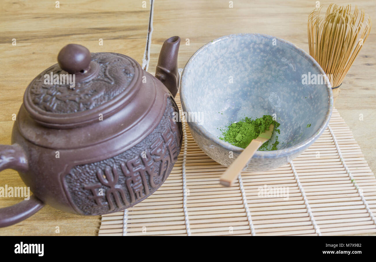 Au-dessus de la cérémonie japonaise du thé y compris un bol en pierre de  poudre de thé vert matcha, fouet en bambou, scoop, et une théière asiatique  brune sur bambou Photo Stock -