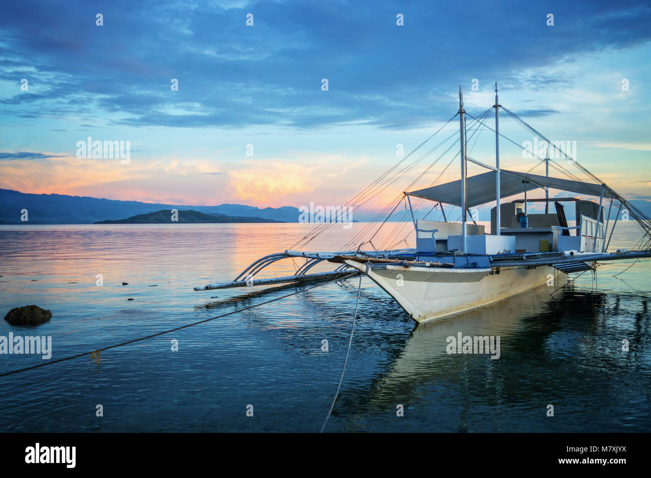 Banka, bateau de pêche traditionnelle des Philippines au coucher du soleil, l'île de Cebu, aux Philippines Banque D'Images