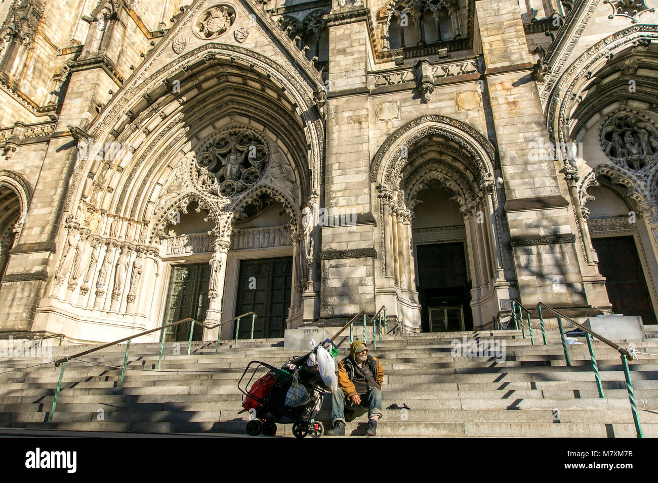 L'homme sans-abri non identifié a trouve himselft et ses effets personnels à l'étapes conduisant à l'portails de la Cathédrale de Saint John the Divine Banque D'Images