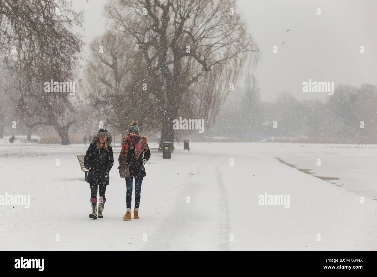 LONDON, UK : Deux jeunes femmes marchant en blanc Regent's Park alors qu'il neige Banque D'Images