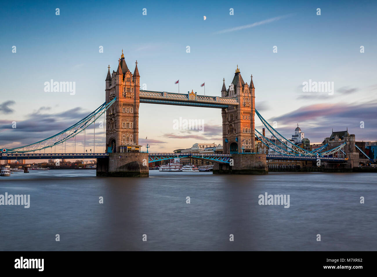Londres, Royaume-Uni - 05 NOVEMBRE 2017 : London's iconic Tower Bridge lors d'un coucher de soleil colorés avec une demi-lune au-dessus d'elle et de la Tamise au premier plan Banque D'Images
