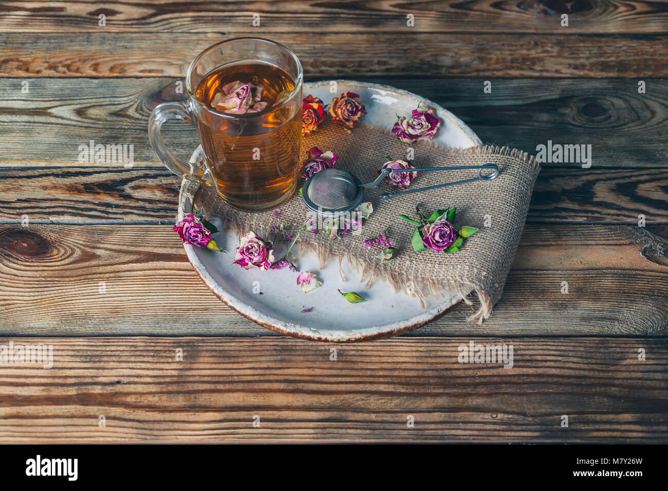 Boutons de rose thé, tasse de thé, de la crépine et le bocal en verre avec boutons de rose. Focus sélectif. Banque D'Images