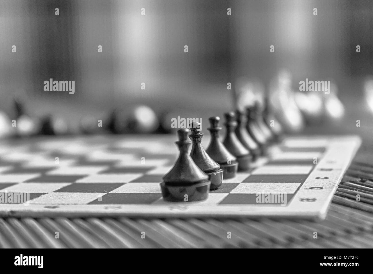 En Bois Monochrome Conseil d'échecs et de l'acier pièces des échecs, isolé à bord. Banque D'Images
