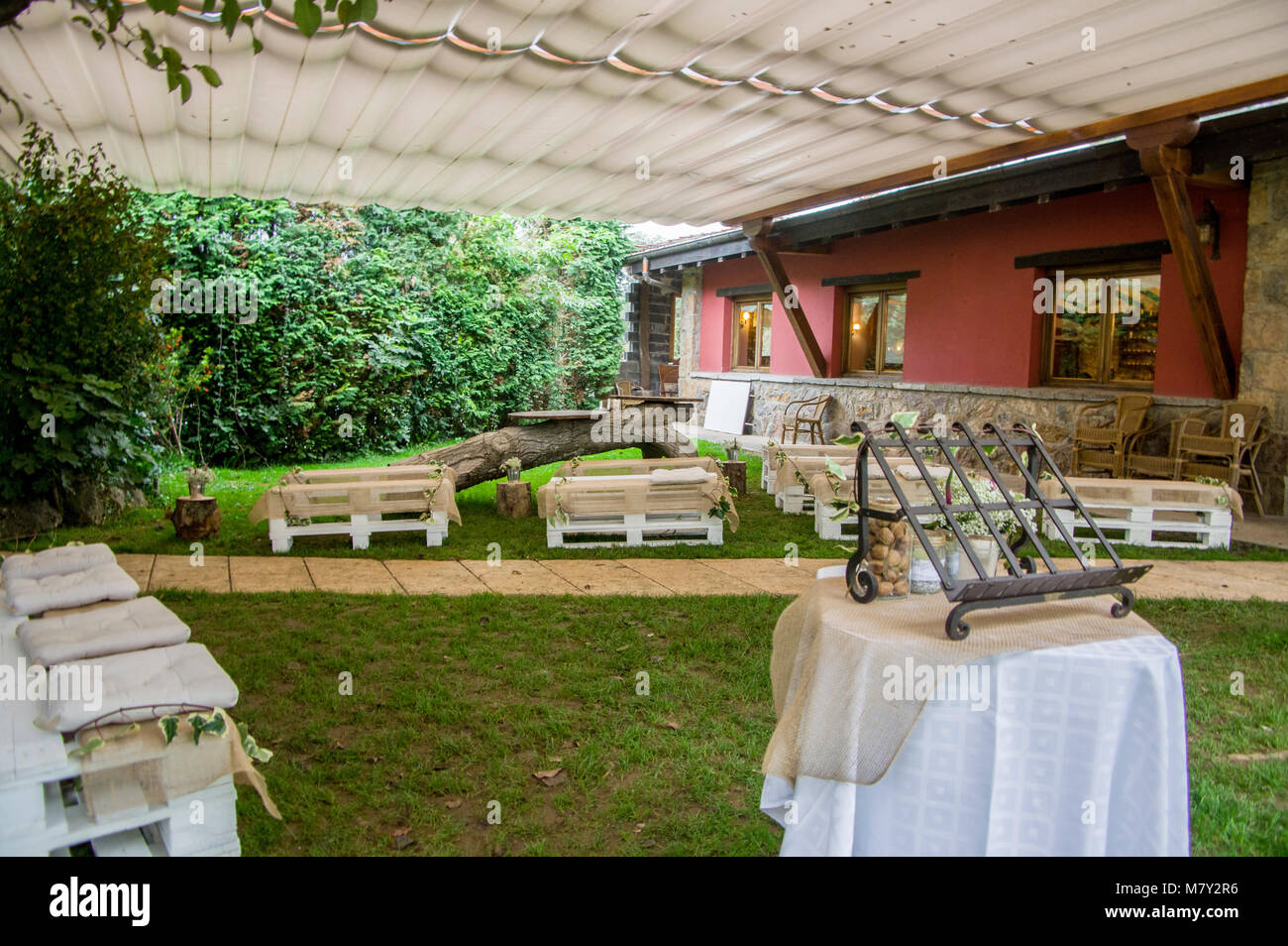 Centre jardin décoré pour son mariage avec des bancs en bois dans le Jai Alai restaurant, Urrestilla, Pays Basque, Espagne Banque D'Images