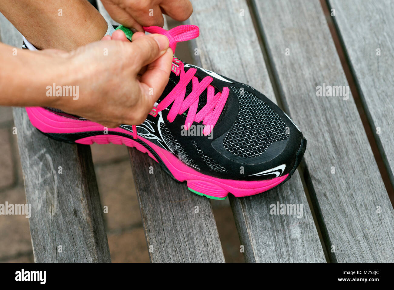 Une femme sa fixation des chaussures de course Banque D'Images