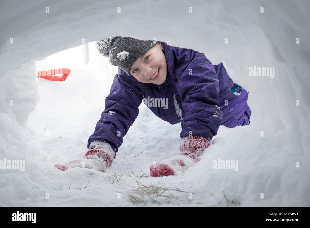 Canadian girl smiling et à la recherche en entrée de tunnel de neige de l'extérieur Banque D'Images