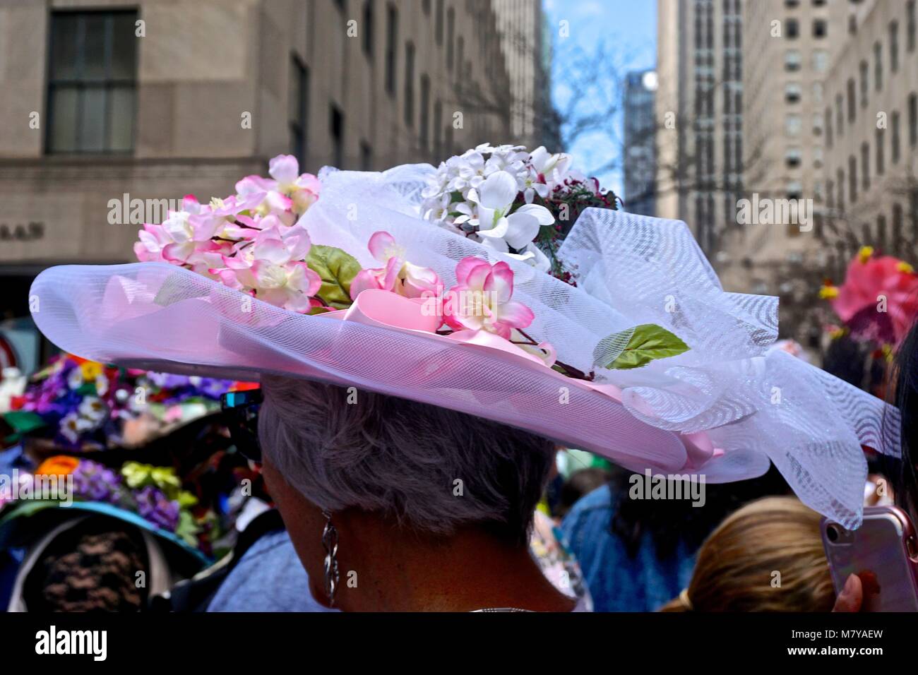 Femme portant un bonnet à fleurs rose et blanc à l'assemblée annuelle, Cinquième Avenue Easter Parade dans la ville de New York. Banque D'Images