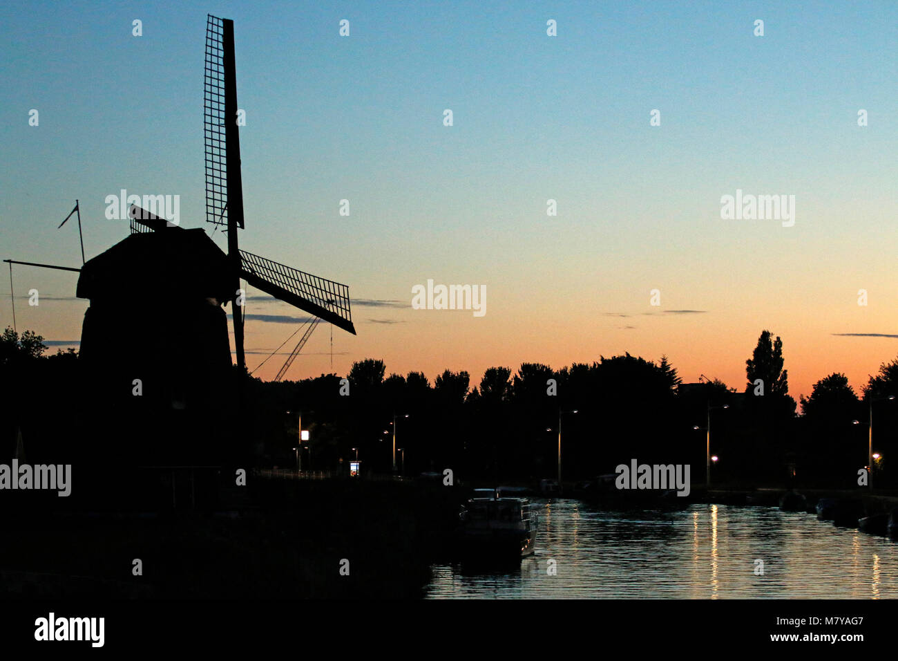 Coucher du soleil avec un ancien moulin à vent et canal Banque D'Images